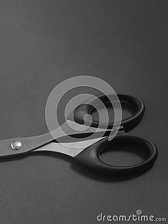 Close up photo of a pair of scissors on a dark background. Stock Photo