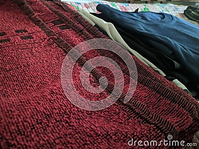 A close-up photo of a pile of clothing with someone holding a cell phone. This asset is suitable for fashion websites. Stock Photo