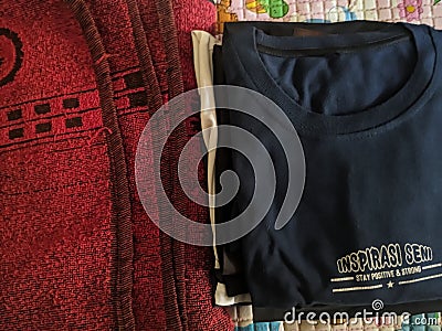 A close-up photo of a pile of clothing with someone holding a cell phone. This asset is suitable for fashion websites. Stock Photo