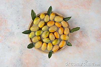 Close up photo, Pile of kumquats on wooden plate Stock Photo