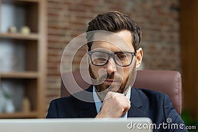 Close-up photo. Portrait of a young man in glasses and a suit of a lawyer, a legal defender who is serious sitting in Stock Photo