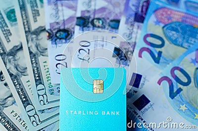 Close up photo of Starling bank card on the dollar, pound, euro banknotes background. Illustrative concept of multi currency accou Editorial Stock Photo