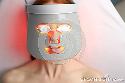 Close-up photo of woman getting photodynamic face mask therapy Stock Photo