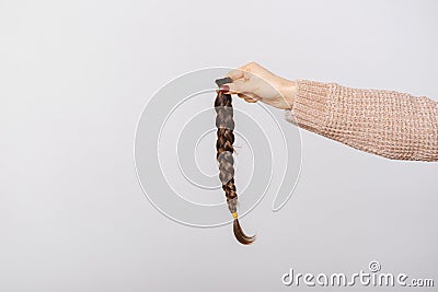 Close up photo of woman holding braided brown hair for donation Stock Photo