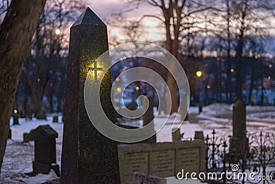 A close up photograph at sunset of a tombstone in a graveyard Stock Photo