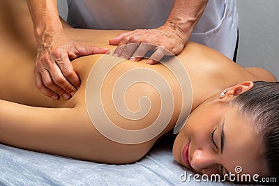 Physiotherapist manipulating shoulder blade on young woman Stock Photo