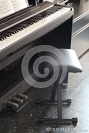 Close up on a piano keyboard with a stool Stock Photo