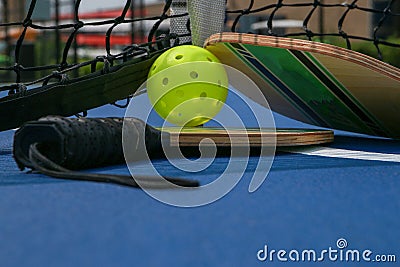 Close up of pickleball paddles and whiffle balls under a net on a court Stock Photo