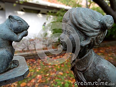 Close up picture of a bronze statue figuring a girl admiring a squirrel Stock Photo