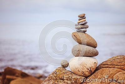 Balance, relaxation and wellness: Stone cairn outside, ocean in the blurry background Stock Photo