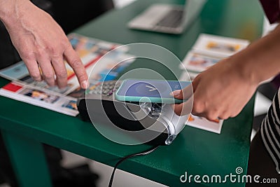 Close-up picture of woman paying using PayPass on the phone Stock Photo