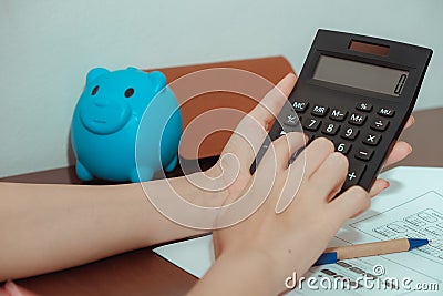 A close-up of a picture of a woman pressing a calculator Stock Photo