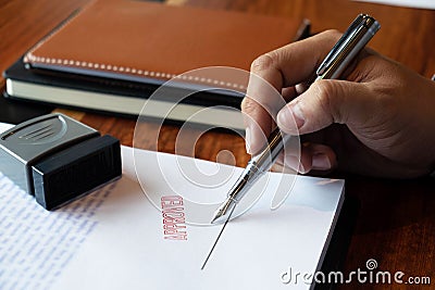 Close-up pictures of the hands of businessmen signing and stamping in approved contract forms Stock Photo
