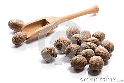Close-up of pile of nutmeg seeds spice in a wooden spoon on whit Stock Photo