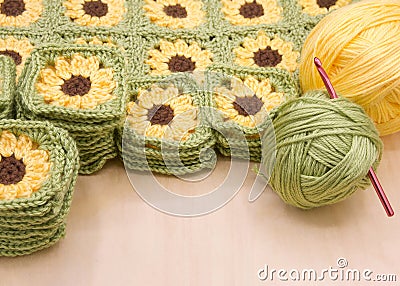 piles of hand crochet granny squares with yellow flowers stacked Stock Photo