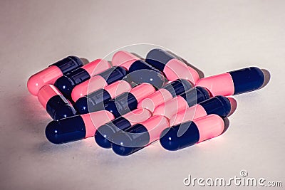 Close up of pink and blue Amoxicillin antibiotics capsule pills. Concept for Antimicrobial drug resistance; pharmaceutical Stock Photo