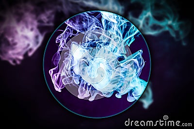 Close-up swirling smoke blown under a magnifying glass Stock Photo