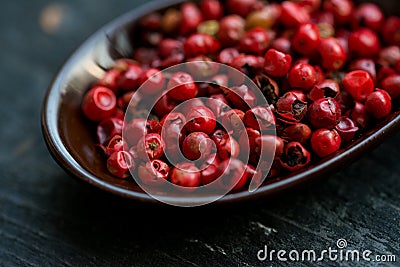 Close up pink peppercorn in spoon dark background Stock Photo