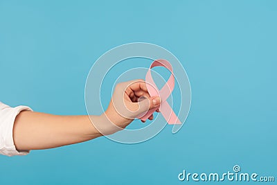 Close up of pink ribbon in hand, symbol of breast cancer awareness, diagnostics and prevention of oncological disease Stock Photo