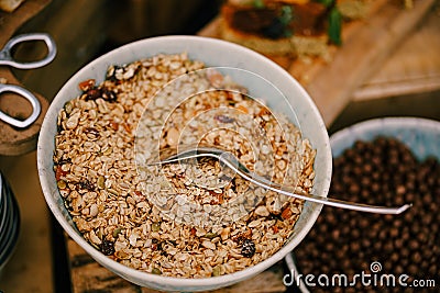 Close-up of a plate of oatmeal with dried fruit on a table with a breakfast cereal balls with cocoa. Stock Photo