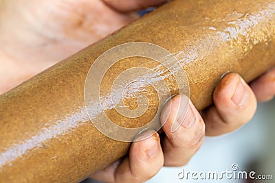 Close-up plumber hand holding used dirty rusty first-stage filter for drinking water. Changing cartridge of home Stock Photo