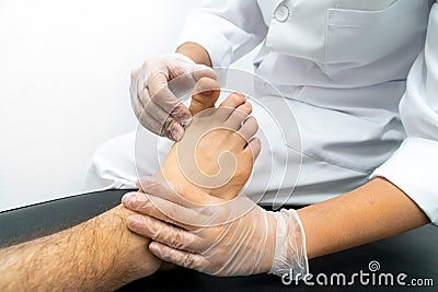 Close-up of a podiatrist performing an examination of a patient on a stretcher. Stock Photo