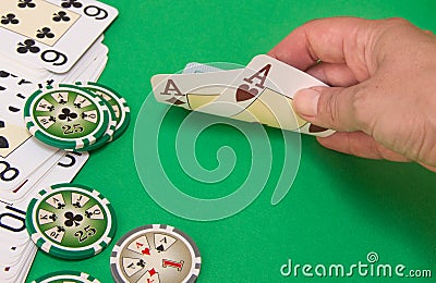 Close up of poker player lifting the corners of two cards Stock Photo