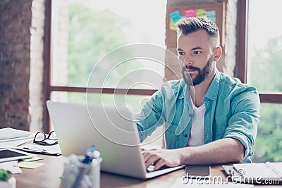 Close up of ponder freelance worker, wearing casual smart, concentrated, focused, serious, sitting at the work place, looking in Stock Photo