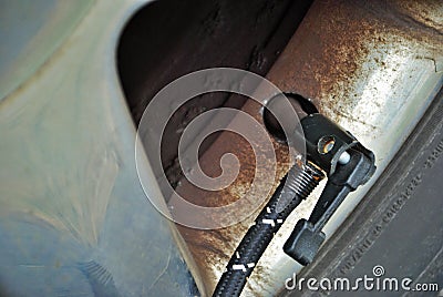 Close up of a portable air compressor connected to the valve stem of a car tire Stock Photo