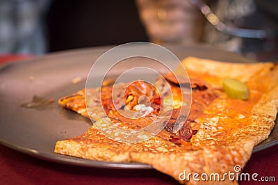 Close up of a portion of delicious crepe with meat served on a grey plate. Stock Photo