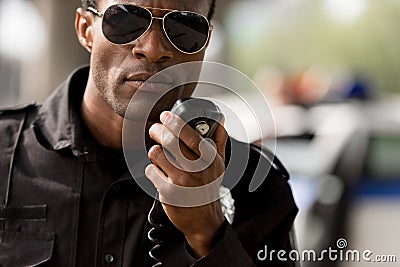 close-up portrait of african american police officer talking by walkie-talkie Stock Photo