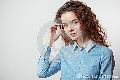 Close up portrait of awasome girl touching her red curly hair Stock Photo