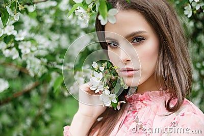 Close-up portrait of a beautiful girl in flowering trees. Flowering fruit trees Stock Photo