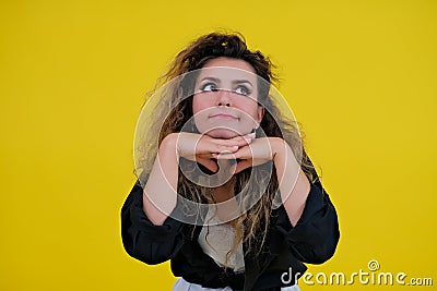 Close-up portrait of a beautiful girl on a yellow background. woman shows thoughtfulness. human emotions Stock Photo