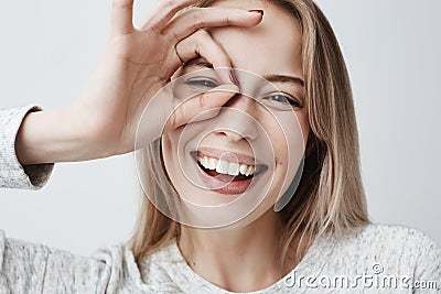 Close up portrait of beautiful joyful blonde Caucasian female smiling, demonstrating white teeth, looking at the camera Stock Photo