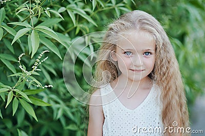 Close up portrait of beautiful little girl with blonde long hair and big blue eyes Stock Photo