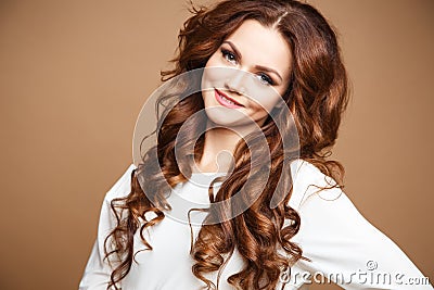 Close-up portrait of beautiful young woman with long brown hair over brown background Stock Photo
