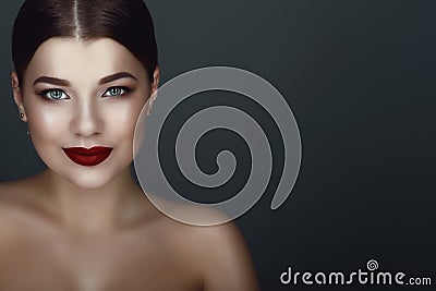 Close up portrait of beautiful smiling dark-haired model with perfect make up and centre part sleek bun Stock Photo