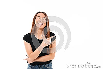 Close-up portrait of beautiful smiling young asian woman pointing with finger, looking at camera Stock Photo