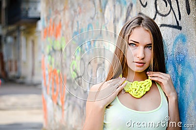 Close up portrait of beautiful stylish fashion girl having fun gently smiling and looking at camera on graffiti city wall Stock Photo