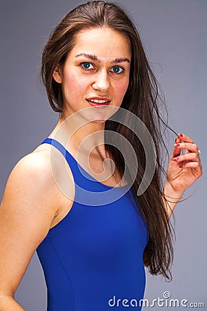 Close up portrait of a beautiful young brunette girl in a blue solid swimsuit Stock Photo