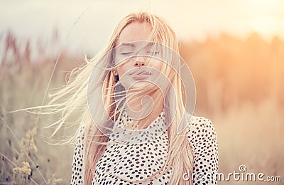 Close Up Portrait of beauty girl with fluttering white hair enjoying nature outdoors, on a field. Flying blonde hair on the wind Stock Photo