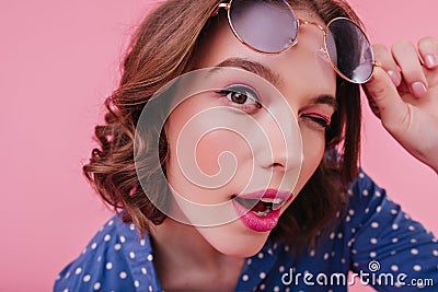 Close-up portrait of blithesome brown-eyed girl isolated on pink background. Studio shot of gorgeou Stock Photo