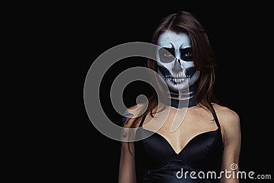 Close up portrait of brown-haired woman with Halloween skull make up over black background Stock Photo