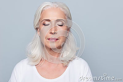 Close up portrait of confident concentrated mature woman with wrinkles on face, with closed eyes, with nude make up, isolated on Stock Photo