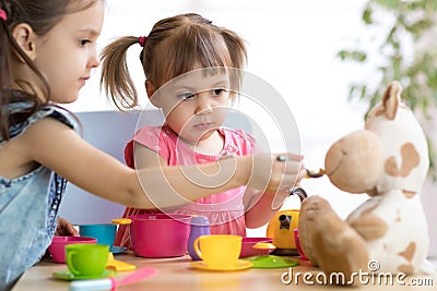 Close-up portrait of cute adorable little kids feeding caw plush toy Stock Photo