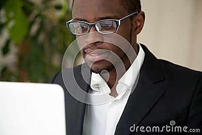 Focused African American CEO looking at laptop screen reading ne Stock Photo