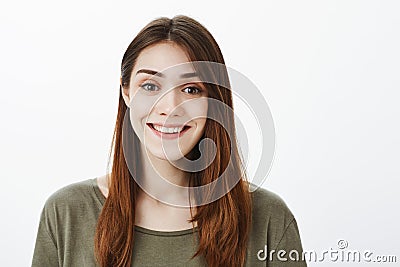 Close-up portrait of good-looking friendly female student in casual outfit, smiling politely, talking casually with Stock Photo
