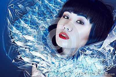 Gorgeous Asian model with beautiful make up and trendy haircut with fringe wearing fancy shining stand-up collar. Stock Photo