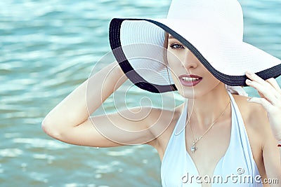 Close up portrait of gorgeous elegant glam lady hiding the half of her face behind the wide brim hat Stock Photo